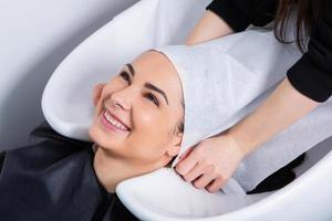 coiffeur professionnel laver les cheveux d'une jeune femme dans un salon de beauté... gros plan des cheveux d'une femme dans un salon de beauté, concept de coiffure photo