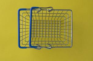 panier vide sur fond coloré. chariot de magasin au supermarché. vente, remise, shopping, vendredi noir, concept d'économie. tendance de la société de consommation. concept d'achat en ligne. photo