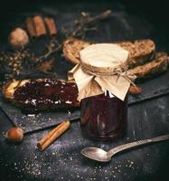 framboise confiture dans une verre pot suivant à un le fer cuillère photo