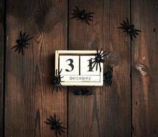 figurines d'araignées noires et horloge rétro en bois faite de blocs avec la date du 31 octobre photo