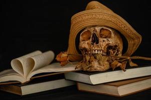 nature morte avec un livre en forme de cœur et un crâne avec des fleurs sèches