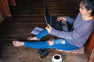 femme travaillant sur un ordinateur portable sur le sol photo