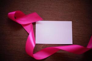 ruban rose et papier blanc sur fond de bois photo