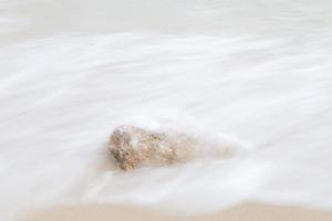 les vagues de la mer ont frappé un rocher photo