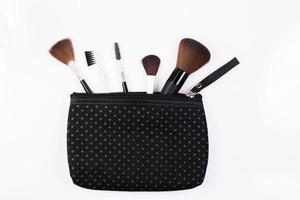 Pinceaux de maquillage dans un sac cosmétique isolé sur fond blanc photo