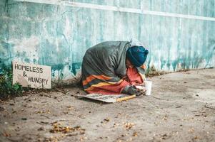 mendiants assis dans la rue avec des messages de sans-abri, veuillez aider photo