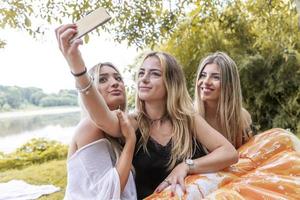 femelle millénaire copines prise une selfie en plein air sur le rivière photo