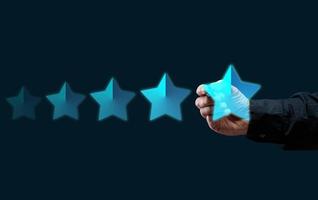 cinq holographique étoiles et une homme main sur une foncé bleu Contexte. affaires évaluation concept par utilisateurs, évaluation et vote photo