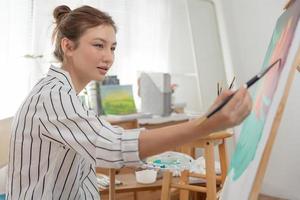 beaux passe-temps féminins sur l'artiste et utiliser le pinceau dans l'art abstrait pour créer un chef-d'œuvre. peinture de peintre à l'aquarelle ou à l'huile dans la maison de studio. aime peindre comme passe-temps, loisir, inspiration photo