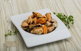 moules dans un bol sur fond de bois photo