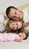 portrait intérieur avec une jeune famille heureuse et un mignon petit bébé photo