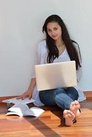 jeune femme détendue à la maison travaillant sur un ordinateur portable photo