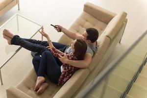 jeune couple sur le canapé devant la télévision photo