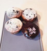 mignonne Pâques poussin petits gâteaux. vanille petits gâteaux avec crème au beurre sur une blanc supporter avec Frais fleurs sur une blanc en bois Contexte photo