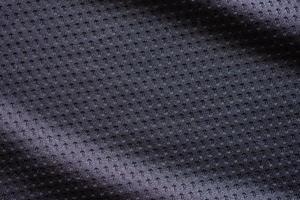 maillot de football de vêtements de sport en tissu noir avec fond de texture en maille d'air photo