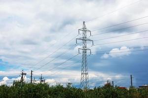 poste haute tension contre un ciel bleu clair. photo