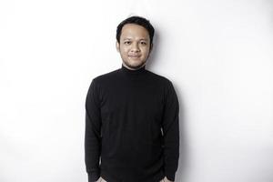 une portrait de une souriant asiatique homme habillé dans une noir chemise, isolé par blanc Contexte photo