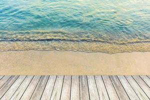 bois pont et vague de le mer sur le sable plage photo