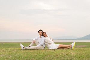 heureux jeune couple asiatique en vêtements de mariée et de marié photo