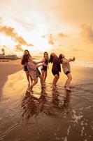 une groupe de indonésien femmes prendre plaisir le plage Heureusement lorsque elles ou ils rencontrer leur copains à le vacances moment photo