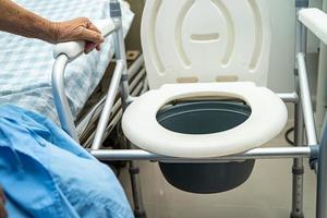 toilettes à chasse d'eau et chaise de douche dans la salle de bain pour personnes âgées. photo