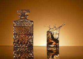 carafe et verre avec whisky sur d'or Contexte photo