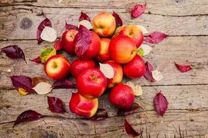 nature morte avec plusieurs pommes rouges allongé sur une vieille table en bois photo