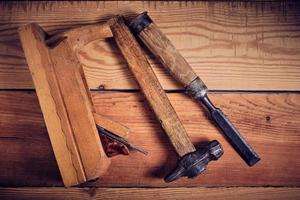 ensemble de outils pour menuisiers, marteau, ciseau et avion sur en bois Contexte. photo