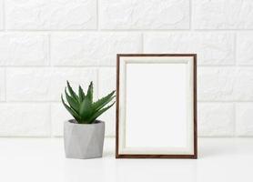cadre photo en bois blanc vide et pots de fleurs avec des plantes sur tableau blanc