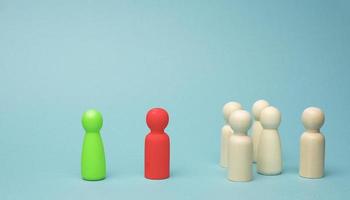 une foule de en bois figurines, une négociateur et une Sur pied vert figurine. le concept de résolution le problème entre le équipe et le directeur, des disputes, conflit de l'intérêt photo