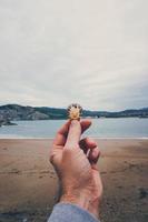 personne tenant une coquille sur la plage photo