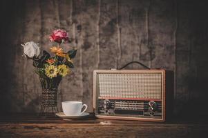 Récepteur radio rétro nature morte avec tasse à café et vases à fleurs