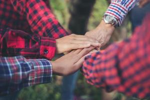 vue rapprochée de jeunes gens mettant leurs mains ensemble photo