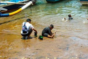 Yogyakarta, Indonésie dans novembre 2022. femelle les pêcheurs qui sont aussi poisson les vendeurs à baron plage sont la lessive leur équipement photo