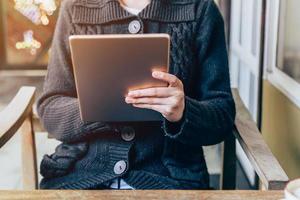 asiatique femme en utilisant tablette sur table dans café magasin avec ancien tonique. photo