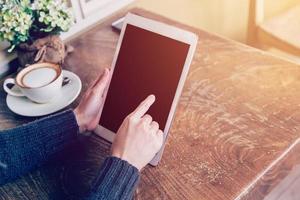 main femme en jouant tablette dans café magasin avec ancien Ton. photo