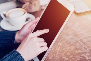 main femme en jouant tablette dans café magasin avec ancien Ton. photo