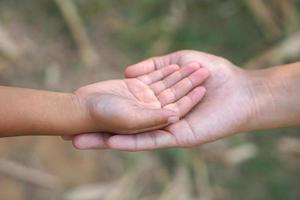 le mains de une enfant et une mère joindre les forces. photo