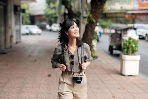 Jeune asiatique femme sac à dos voyageur profiter rue culturel local endroit et sourire. photo