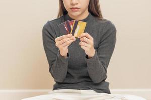 financier devoir, main de asiatique femme, fille main dans holding, à la recherche à beaucoup crédit carte, stressé par calculer frais de facture, non argent à payer, hypothèque ou prêt. dette, la faillite ou faillite. photo