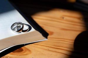 deux mariage anneaux sont mis sur le ouvert Bible mis sur le table comme mariage anneaux préparé pour les amoureux à porter et lis Bible passages comme une promettre à chaque autre. copie espace pour texte photo