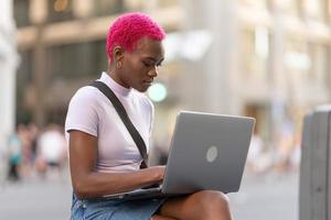 africain Jeune femme travail avec portable sur le rue photo