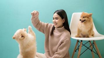 portrait de Jeune magnifique femme baisers et câlins sa chien plus de vert Contexte. photo