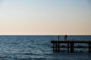 silhouettes de gens sur une abandonné jetée photo