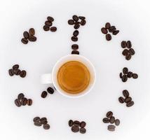 café des haricots forme une l'horloge avec une fumant tasse de café dans le centre, avec une blanc Contexte photo