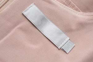 étiquette de vêtements de soin de blanchisserie vierge sur fond de texture de tissu photo