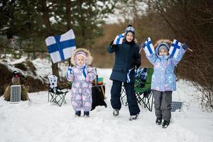 Trois finlandais les enfants avec Finlande drapeaux sur une agréable hiver journée. nordique scandinave personnes. photo