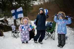 Trois finlandais les enfants avec Finlande drapeaux sur une agréable hiver journée. nordique scandinave personnes. photo