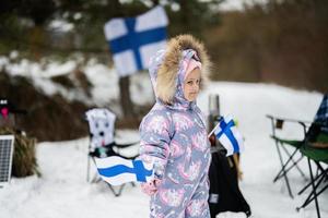 finlandais bébé fille avec Finlande drapeaux sur une agréable hiver journée. nordique scandinave personnes. photo