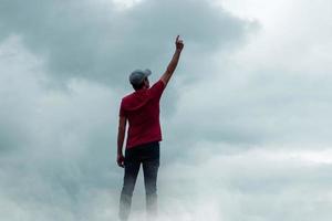 homme portrait faire des gestes dans le ciel et des nuages photo